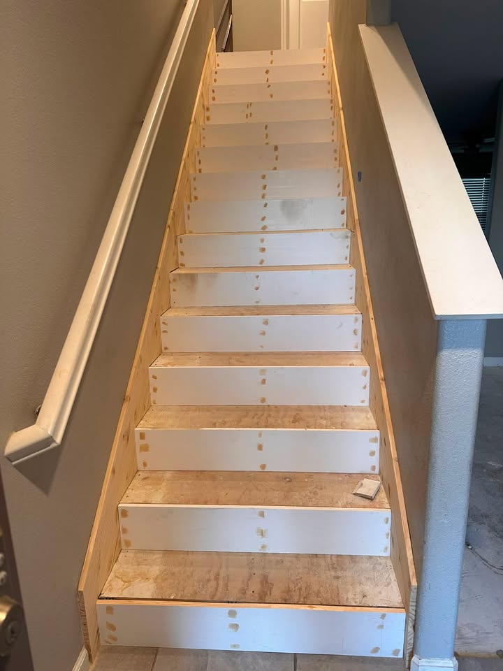 Staircase before the rebuild, showing bare plywood treads and risers