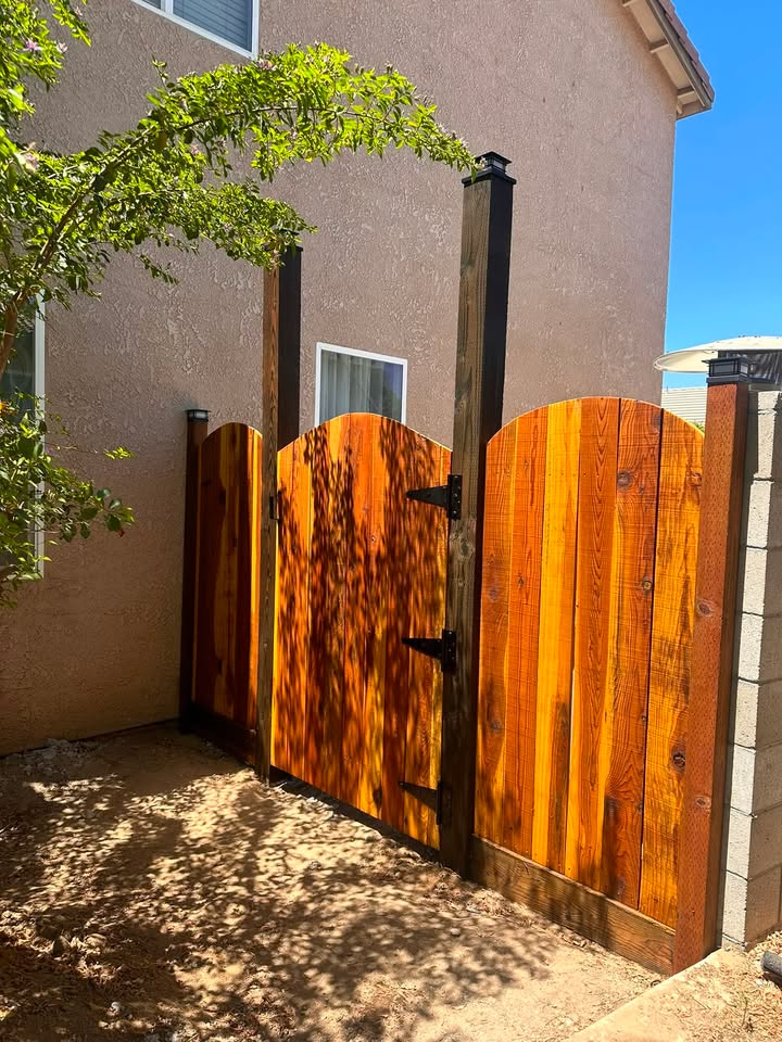 Cedar-toned wood fence and arched gate, viewed from the front side